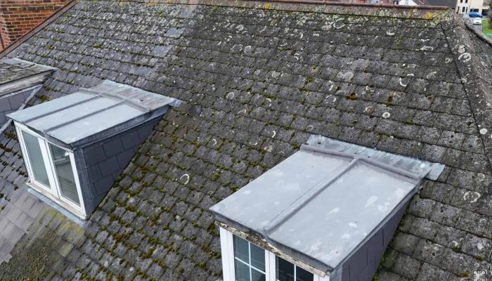 An aerial close up view of a roof with two dormer windows.