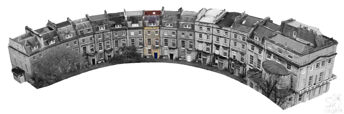 Row of historic townhouses in a curved street scene.