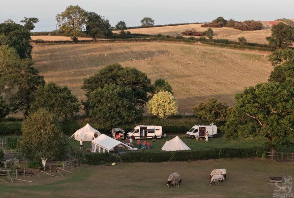Petestock 2025 taken from a drone, featuring a camping setup and horses in the foreground.