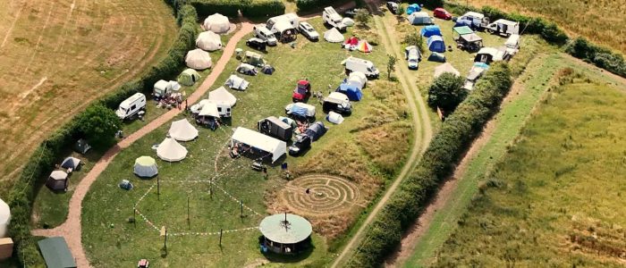 Rising Festival 2025, showing a field full of tents and camper vans.